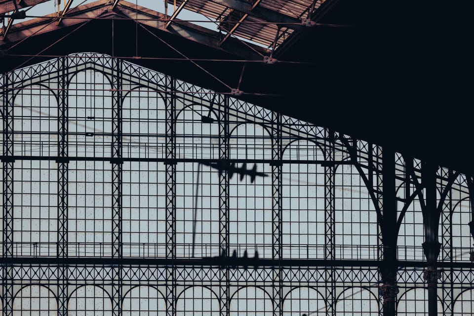 The ironwork and glass arches of a grand market hall in low light.