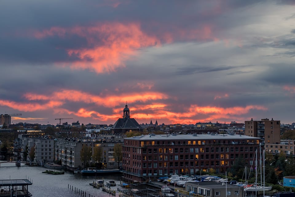 A fiery sunset sky burning over the rooftops and harbour of Amsterdam.
